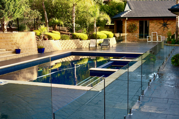 glass pool fencing around swimming pool on property